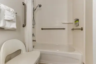 a small bathroom with a toilet and a bath tub at Holiday Inn Express - Cincinnati North - Monroe by IHG in Monroe