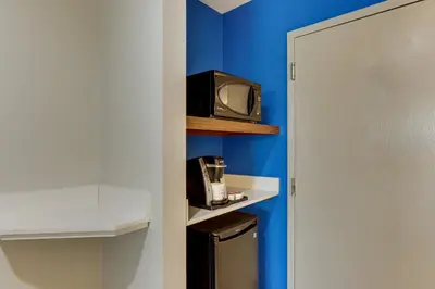 a small tv sitting on a shelf next to a refrigerator at Holiday Inn Express - Cincinnati North - Monroe by IHG in Monroe