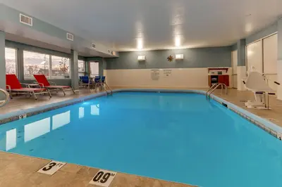 a large pool with blue water in a building at Holiday Inn Express - Cincinnati North - Monroe by IHG in Monroe