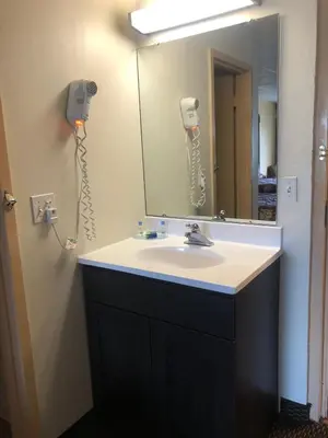 a bathroom with a sink and a mirror at Wolf Inn Hotel in Sandusky