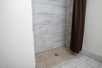 a bathroom with a shower with a tiled floor at BlissPoint Inn & Suites Marion in Marion