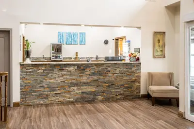a living room with a brick wall and a chair at BlissPoint Inn & Suites Marion in Marion