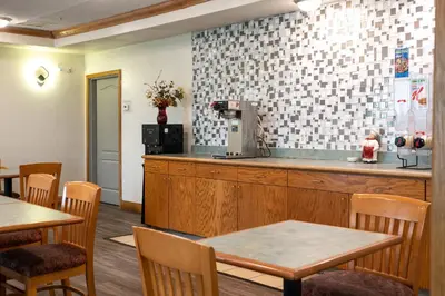 a restaurant with a counter and tables and chairs at BlissPoint Inn & Suites Marion in Marion