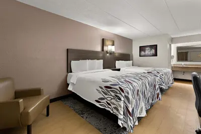 a hotel room with a large bed and a chair at Red Roof Inn Cleveland - Westlake in Westlake