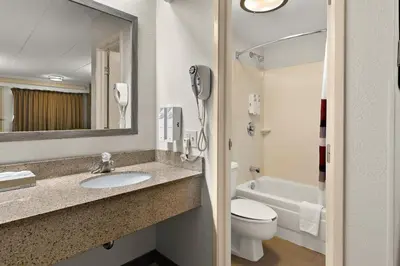 a bathroom with a sink and a toilet and a phone at Red Roof Inn Cleveland - Westlake in Westlake