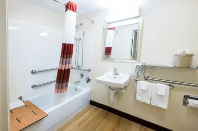 a bathroom with a sink and a tub and a toilet and a mirror at Red Roof Inn Cleveland - Westlake in Westlake