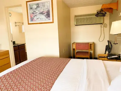 a hotel room with a bed and a desk at Sandusky Inn in Sandusky