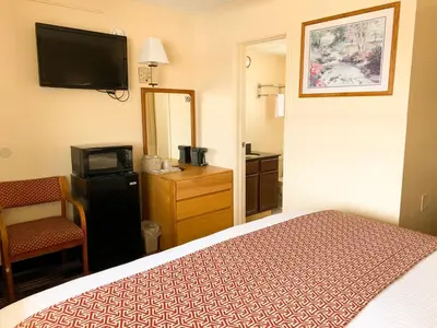 a hotel room with a bed and a television at Sandusky Inn in Sandusky