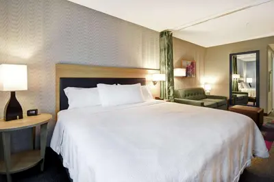 a hotel room with a large white bed and a chair at Home2 Suites By Hilton Georgetown in Georgetown