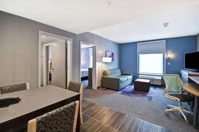 a room with a table and chairs and a living room at Home2 Suites By Hilton Georgetown in Georgetown