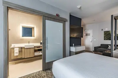 a hotel room with a bed and a bathroom at SpringHill Suites by Marriott Fort Wayne North in Sunnybrook Acres