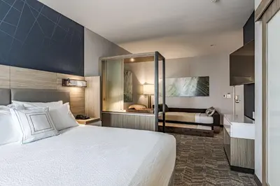 a hotel room with a large bed and a bathroom at SpringHill Suites by Marriott Fort Wayne North in Sunnybrook Acres