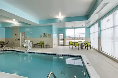 a pool with tables and chairs in a building at SpringHill Suites by Marriott Fort Wayne North in Sunnybrook Acres