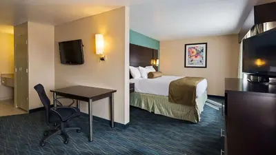 a hotel room with a bed and a desk and a tv at Baymont by Wyndham Marion, OH in Marion