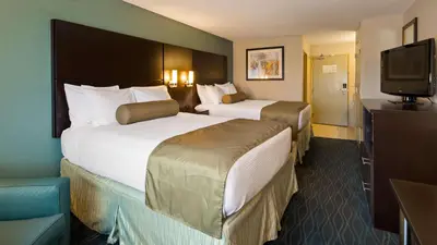 a hotel room with two beds and a flat screen tv at Baymont by Wyndham Marion, OH in Marion