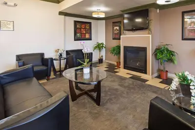 a waiting room with a couch and a table and a fireplace at Baymont by Wyndham Marion, OH in Marion