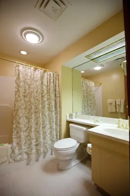 a bathroom with a toilet and a sink and a mirror at The Bertram Inn at Glenmoor in Canton