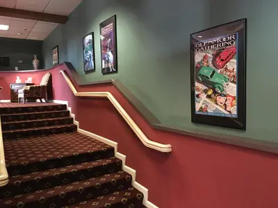 a set of stairs with a movie poster on the wall at The Bertram Inn at Glenmoor in Canton