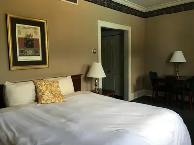 a bedroom with a white bed with a pillow on it at The Bertram Inn at Glenmoor in Canton