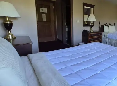 a bedroom with a bed and a dresser and a mirror at The Bertram Inn at Glenmoor in Canton