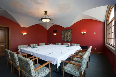 a dining room with a white table and chairs at The Bertram Inn at Glenmoor in Canton