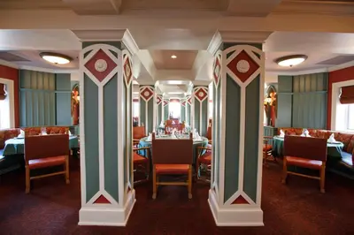 a dining room with tables and chairs and columns at The Bertram Inn at Glenmoor in Canton