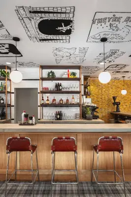 a restaurant with two red chairs at a bar at Graduate by Hilton Columbus in Columbus