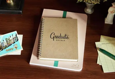 a notebook sitting on top of a wooden table at Graduate by Hilton Columbus in Columbus