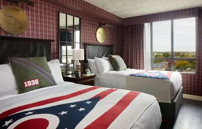 a bedroom with two beds with an american flag blanket at Graduate by Hilton Columbus in Columbus