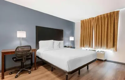 a bedroom with a bed and a desk and a chair at Extended Stay America Suites - Fort Wayne - South in Fort Wayne