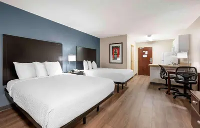 a hotel room with a large bed and a desk at Extended Stay America Suites - Fort Wayne - South in Fort Wayne