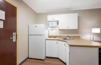 a kitchen with a white refrigerator and a sink at Extended Stay America Suites - Fort Wayne - South in Fort Wayne