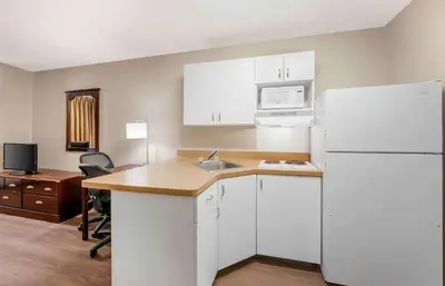a kitchen with a white refrigerator and a sink at Extended Stay America Suites - Fort Wayne - South in Fort Wayne