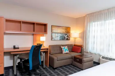 a hotel room with a desk and a couch at TownePlace Suites Fort Wayne North in Fort Wayne