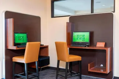 two desks with two computers on them with orange chairs at TownePlace Suites Fort Wayne North in Fort Wayne