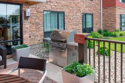 a grill on a patio next to a building at TownePlace Suites Fort Wayne North in Fort Wayne