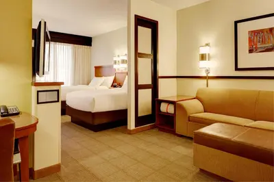 a hotel room with two beds and a couch at Hyatt Place Fort Wayne - Northwest in Fort Wayne