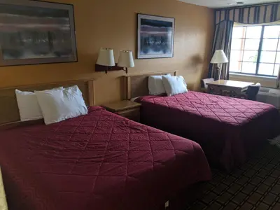 a hotel room with two beds and a window at Executive Inn in Fort Wayne