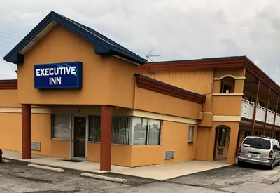 a building with a sign that reads executive inn at Executive Inn in Fort Wayne