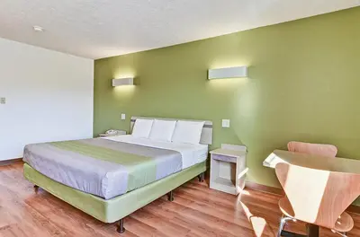 a bedroom with a large bed with green walls at Economy Inn Pittsburgh Airport in Moon