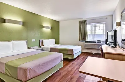 a hotel room with two beds and a flat screen tv at Economy Inn Pittsburgh Airport in Moon