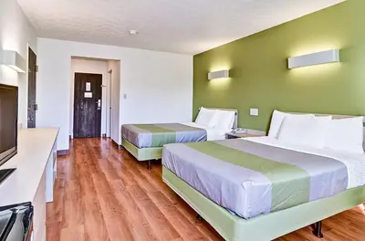 a hotel room with two beds and a flat screen tv at Economy Inn Pittsburgh Airport in Moon