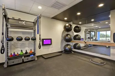 a fitness room with a gym with a mirror at Tru By Hilton Huber Heights Dayton in Huber Heights