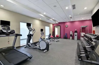a gym with two treadmills and two exercise bikes at Home2 Suites By Hilton Dayton South in Miamisburg