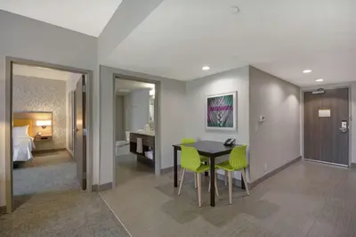 a room with a table and chairs and a bedroom at Home2 Suites By Hilton Dayton South in Miamisburg
