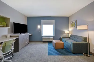 a living room with a couch and a tv at Home2 Suites By Hilton Dayton South in Miamisburg