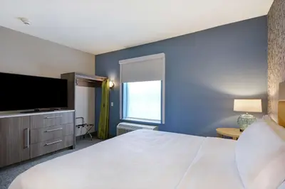 a hotel room with a large bed and a television at Home2 Suites By Hilton Dayton South in Miamisburg