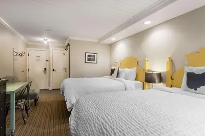 a hotel room with two beds and a desk at The Aurora Inn Hotel and Event Center in Aurora