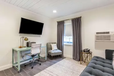 a living room with a desk and a tv at The Aurora Inn Hotel and Event Center in Aurora