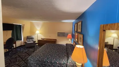a hotel room with a bed and a blue wall at Guest Keeper Inn in Van Wert